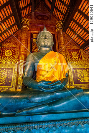 Statue of Buddha in small temple near Wat Chedi Luang temple, Thailand. Spiritual place with beautiful ornaments and textures. Famous tourist destination Statue of Buddha in small temple near Wat Chedi Luang temple, Thailand. Spiritual place with beautiful ornaments and textures. Famous tourist destination 139050641