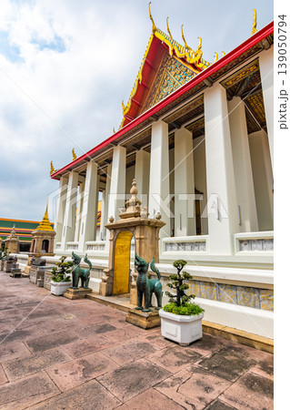 Wat Pho temple in Bangkok city, Thailand. Ancient buddhism temple, view of building with lying Buddha statue inside. Famous tourist destination. Religion building. Wat Pho temple in Bangkok city, Thailand. Ancient buddhism temple, view of building with lying Buddha statue inside. Famous tourist destination. Religion building. 139050794