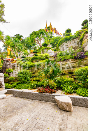 Small garden with water pond, Buddha statue and flowers near the Wat Saket temple (Golden mount) in Bangkok, Thailand. Famous religion building on top of the mountain in center of city. Small garden with water pond, Buddha statue and flowers near the Wat Saket temple (Golden mount) in Bangkok, Thailand. Famous religion building on top of the mountain in center of city. 139050804