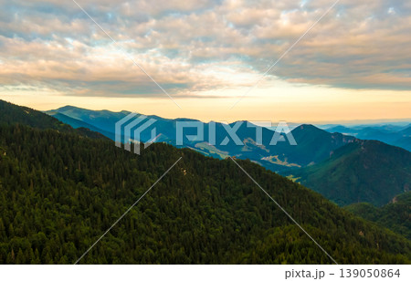 Aerial view to Mala Fatra mountains in Slovakia. Sunrise above mountain peaks and hills in far. Beautiful nature, vibrant colors. Famous tourist destination for hiking and trekking. Cloudy weather. 139050864