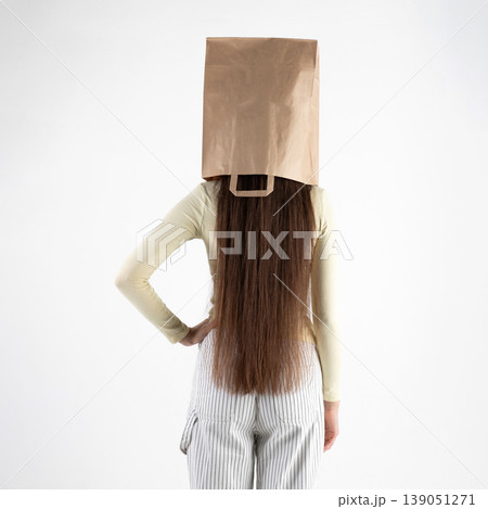 Person standing with brown paper bag on head hiding identity Person standing with brown paper bag on head hiding identity 139051271