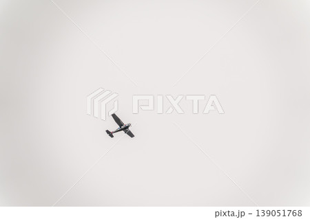 Small ultralight airplane with overhead wing and single propeller flying in sunset sky. Small ultralight airplane with overhead wing and single propeller flying in sunset sky. 139051768