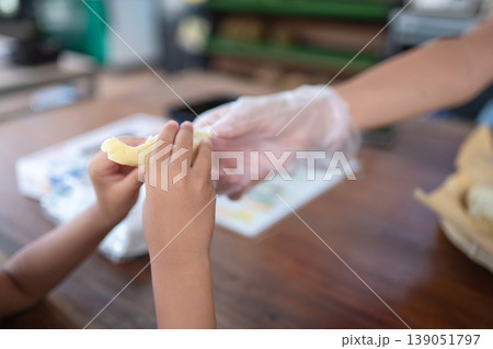 Child's Hands Receiving Durian in Local Market Setting 139051797