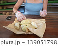 Woman Enjoying Fresh Durian at Local Market with Protective Gloves 139051798