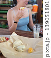 Young Woman Enjoying Durian Delicacies at a Bustling Market Buffet 139051801