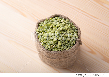 Green pea in linen bag on wooden table. Little bag with split green pea Green pea in linen bag on wooden table. Little bag with split green pea 139051830