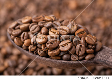 Dark roasted coffee beans in wooden spoon. Background of fresh roasted coffee grain 139051844