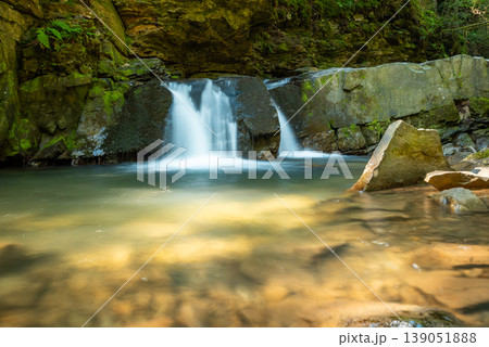 Girl`s Tears waterfall in Carpathians near the town on Yaremche. Shot of a beautiful waterfall on a long exposure on a sunny summer day Girl`s Tears waterfall in Carpathians near the town on Yaremche. Shot of a beautiful waterfall on a long exposure on a sunny summer day 139051888