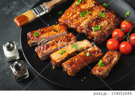 Hot grilled spare ribs from a summer BBQ served on a plate with sauce. Top view. Copy space 139052049