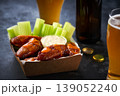 Spicy Buffalo chicken wings with blue cheese sauce and beer in a paper tray on a dark table. crunchy buffalo chicken wings with beer and blue cheese dipping sauce on a dark table. 139052240