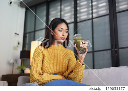 A woman enjoying green smoothie as part of a healthy lifestyle. 139053177