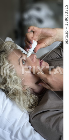 A woman puts drops in her own eyes A woman puts drops in her own eyes 139053515