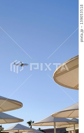 Landing over the beach: plane in the sky above the resort Landing over the beach: plane in the sky above the resort 139053518