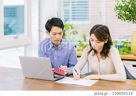 家計管理 家計簿を見つめる夫婦 139054519