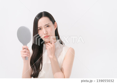 鏡を見て肌トラブルに悩む女性 139055032