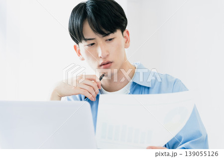 資料を見ながら考える若い男性 139055126