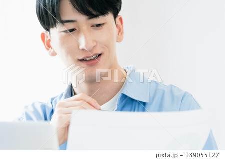 資料を見ながら考える若い男性 139055127
