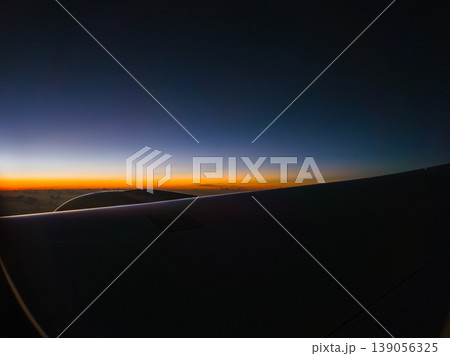 航空機の翼越しに見る夜明けの空 139056325