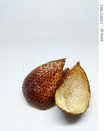 Front view of an empty peeled snake fruit shell showing its scaly texture, isolated on a white background with copy space 139057662