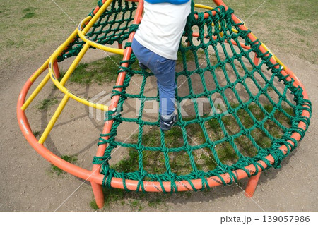 公園のアスレチック遊具に登る子供の後ろ姿 公園のアスレチック遊具に登る子供の後ろ姿 139057986