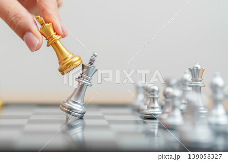 hand moving gold Chess King figure and Checkmate opponent during chessboard competition. Strategy, Success, management, business planning, win, disruption, Trade war and leadership concept hand moving gold Chess King figure and Checkmate opponent during chessboard competition. Strategy, Success, management, business planning, win, disruption, Trade war and leadership concept 139058327