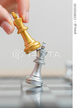 hand moving gold Chess King figure and Checkmate opponent during chessboard competition. Strategy, Success, management, business planning, win, disruption, Trade war and leadership concept 139058330