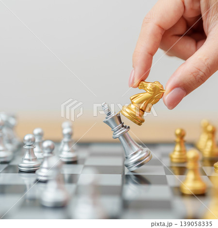 hand moving gold Chess knight figure and Checkmate opponent during chessboard competition. Strategy, Success, management, business planning, win, disruption, Trade war and leadership concept hand moving gold Chess knight figure and Checkmate opponent during chessboard competition. Strategy, Success, management, business planning, win, disruption, Trade war and leadership concept 139058335