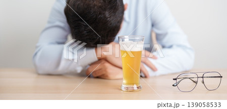 Stressed man drinking beer alone with problem. Exhausted drunk man looking stressed and sleepy. Alcohol addiction, Alcoholism, emotional distress and mental health concept Stressed man drinking beer alone with problem. Exhausted drunk man looking stressed and sleepy. Alcohol addiction, Alcoholism, emotional distress and mental health concept 139058533