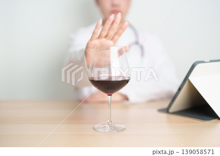 Doctor hand stop to refuse Wine, quitting drink for healthy liver, prevent Alcoholic cirrhosis and cancer, World No Alcohol Day, medical advice for sobriety and Alcoholism and addiction concept 139058571