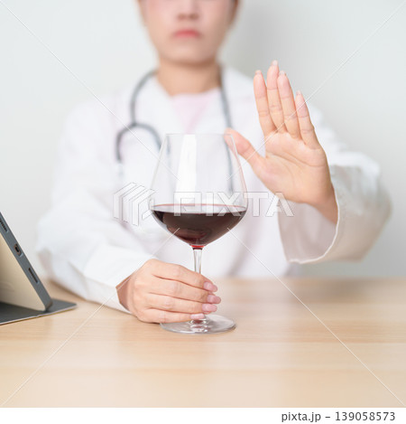 Doctor hand stop to refuse Wine, quitting drink for healthy liver, prevent Alcoholic cirrhosis and cancer, World No Alcohol Day, medical advice for sobriety and Alcoholism and addiction concept Doctor hand stop to refuse Wine, quitting drink for healthy liver, prevent Alcoholic cirrhosis and cancer, World No Alcohol Day, medical advice for sobriety and Alcoholism and addiction concept 139058573