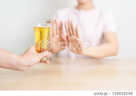 woman making stop hand gesture to refuse a glass of Beer, Healthy man say no to alcohol drink, stop alcoholism and addiction concept. Responsible man reject a drink before driving and quit booze woman making stop hand gesture to refuse a glass of Beer, Healthy man say no to alcohol drink, stop alcoholism and addiction concept. Responsible man reject a drink before driving and quit booze 139058598