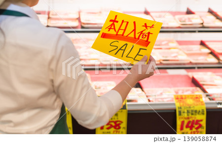 店員が「SALE」と書かれた黄色い札を持つ 139058874