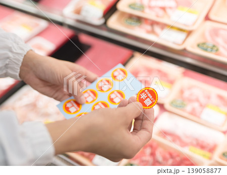 スーパーで値引きシールを貼る作業員 スーパーで値引きシールを貼る作業員 139058877