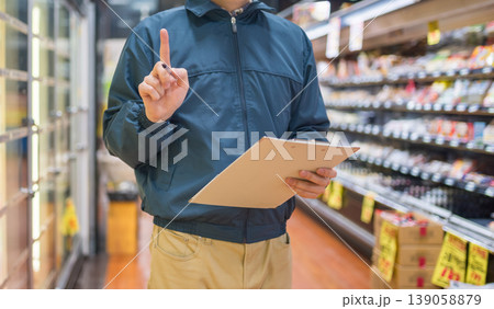 スーパーで指差し確認する男性店員 スーパーで指差し確認する男性店員 139058879