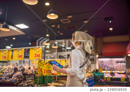 タブレットを持つスーパー店員の後ろ姿 タブレットを持つスーパー店員の後ろ姿 139058930