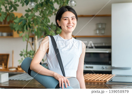 家でヨガマットを持つ女性(ワークアウト・ヨガ・ピラティス) 家でヨガマットを持つ女性(ワークアウト・ヨガ・ピラティス) 139058979