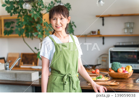 キッチンの前にいるエプロン姿の中高年のアジア人女性 キッチンの前にいるエプロン姿の中高年のアジア人女性 139059038