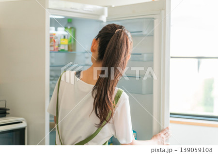 料理,自炊,冷蔵庫から食材を取り出す中高年の女性 料理,自炊,冷蔵庫から食材を取り出す中高年の女性 139059108