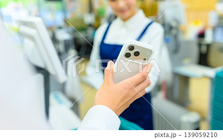 レジでスマホ決済する女性 139059210