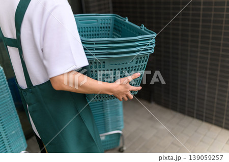 男性店員が買い物かごを持つ 男性店員が買い物かごを持つ 139059257