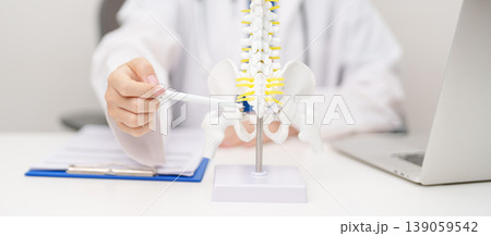 Doctor with human Spine anatomy model. Spinal Cord Disorder and disease, Back pain, Lumbar, Sacral pelvis, Cervical neck, Thoracic, Coccyx, Orthopedist, chiropractic, Office Syndrome and health Doctor with human Spine anatomy model. Spinal Cord Disorder and disease, Back pain, Lumbar, Sacral pelvis, Cervical neck, Thoracic, Coccyx, Orthopedist, chiropractic, Office Syndrome and health 139059542