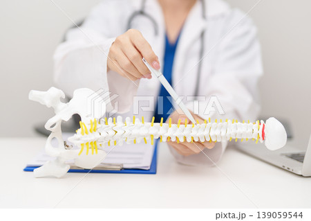 Doctor with human Spine anatomy model. Spinal Cord Disorder and disease, Back pain, Lumbar, Sacral pelvis, Cervical neck, Thoracic, Coccyx, Orthopedist, chiropractic, Office Syndrome and health Doctor with human Spine anatomy model. Spinal Cord Disorder and disease, Back pain, Lumbar, Sacral pelvis, Cervical neck, Thoracic, Coccyx, Orthopedist, chiropractic, Office Syndrome and health 139059544