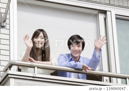 ベランダから手を振る若い夫婦 ベランダから手を振る若い夫婦 139060047