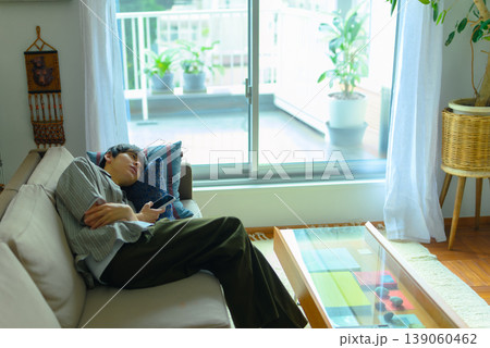 ソファでうたた寝する若い男性 ソファでうたた寝する若い男性 139060462
