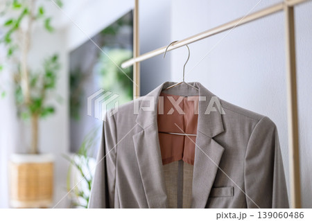 ハンガーラックに掛けられたグレーのジャケット 139060486