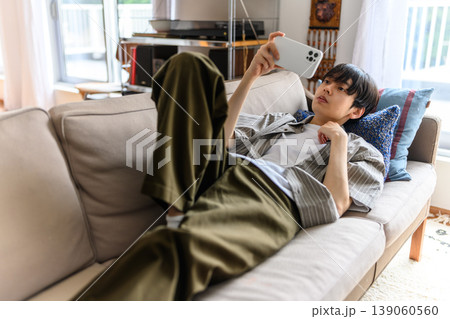 ソファでスマホを自撮りする若い男性 ソファでスマホを自撮りする若い男性 139060560