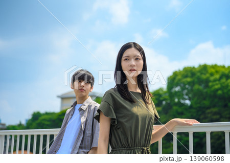 都会の景色を背景に立つ若い女性と男性 都会の景色を背景に立つ若い女性と男性 139060598