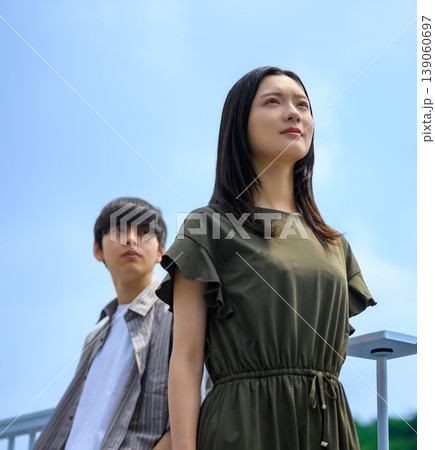 見上げる女性と後方の男性 139060697