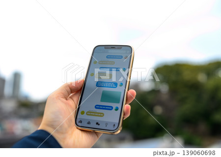 屋外でメッセージアプリを使うスマホ 屋外でメッセージアプリを使うスマホ 139060698