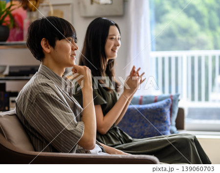 ソファで並んで座る若い男女 139060703